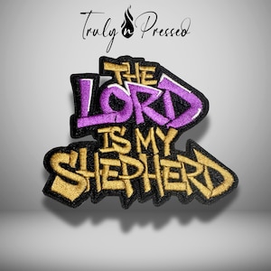 May include: Embroidered patch with the text "THE LORD IS MY SHEPHERD" in purple and gold. The patch has a black border and a stylized design. The words are in a graffiti-style font. The brand name "Truly Pressed" is at the top.