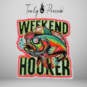 May include: An embroidered patch featuring a colorful fish wearing a baseball cap and sunglasses. The text WEEKEND HOOKER is stitched in black with a neon green outline. The patch has a bright pink border and the Truly n Pressed logo above.