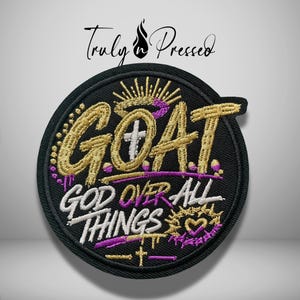 May include: A circular black embroidered patch featuring the gold text GOAT with a halo and a small white cross. Below, the white text GOD OVER ALL THINGS is displayed with a crown of thorns, a heart, and a small cross in gold and purple thread.