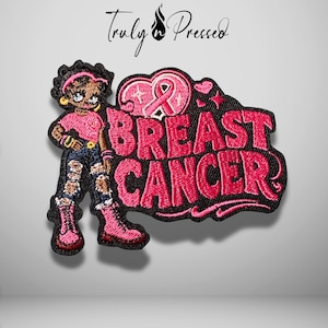 May include: An embroidered patch featuring a cartoon character with dark hair wearing a pink top, distressed blue jeans, and pink boots. Next to the character is a pink heart with a ribbon and the text BREAST CANCER in bold pink lettering.