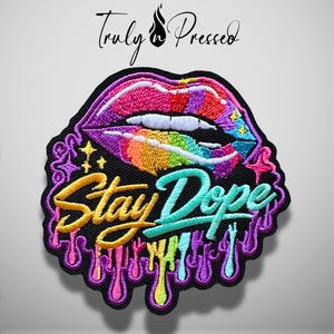 May include: An embroidered patch featuring a pair of lips with a rainbow-colored gradient design. Below the lips, the text "Stay Dope" is stitched in yellow and teal. The design includes purple dripping accents and small star shapes.