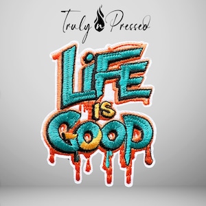 May include: An embroidered patch featuring the text Life is Good in a graffiti-style font. The letters are teal with orange outlines and a dripping paint effect at the bottom. The word is set against a white background with a Truly Pressed logo above.