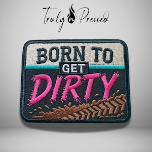May include: A rectangular embroidered patch featuring the text BORN TO GET DIRTY. The top section is beige with black text, separated by a teal line from the bottom black section with pink text and a brown mud splatter design with tire tracks.