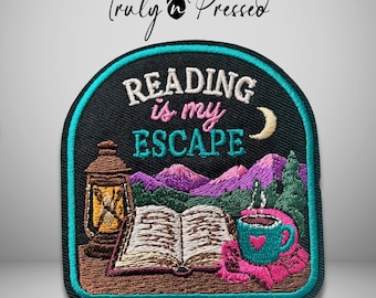 May include: A black embroidered patch with a teal border featuring an open book, a lantern, a teal mug with a pink heart, and purple mountains. The text reads "READING is my ESCAPE" in white and pink, with a small crescent moon above the mountains.