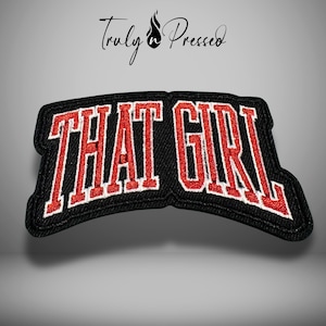 May include: Black patch with the words "THAT GIRL" in red, outlined in white. The patch has a denim-like texture and is slightly curved. The brand name "Truly Pressed" is written in cursive above the patch.