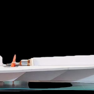 Peut inclure: Maquette d'avion blanche au design &eacute;pur&eacute;, avec un empennage et des ailes pro&eacute;minents. Le mod&egrave;le a un cockpit et est expos&eacute; sur une surface transparente sur fond noir. La maquette d'avion est une r&eacute;plique &agrave; l'&eacute;chelle.