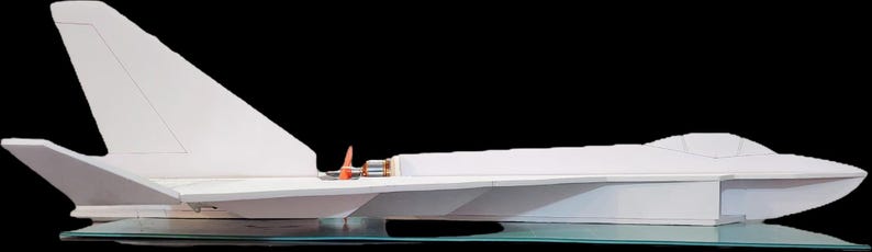 Peut inclure: Maquette d'avion blanche au design &eacute;pur&eacute;, avec un empennage et des ailes pro&eacute;minents. Le mod&egrave;le a un cockpit et est expos&eacute; sur une surface transparente sur fond noir. La maquette d'avion est une r&eacute;plique &agrave; l'&eacute;chelle.
