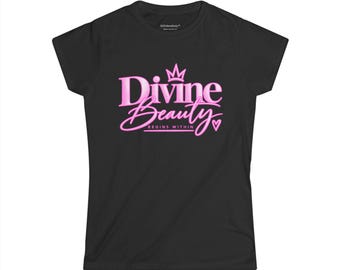 May include: A black short-sleeved t-shirt featuring a pink graphic print on the chest. The text reads Divine Beauty in a stylized font with a crown icon above the word Divine and the text BEGINS WITHIN below, accompanied by a small heart icon.