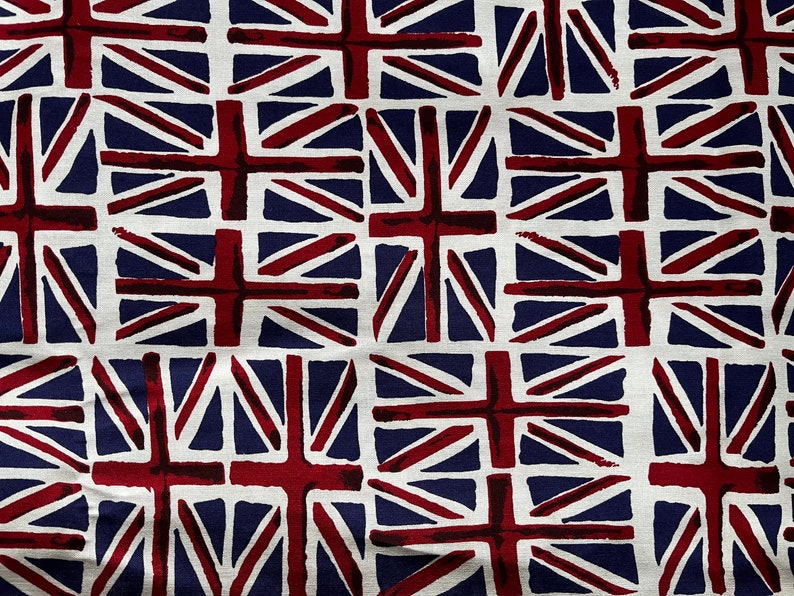 Puede incluir: Una tela blanca con un patr&oacute;n repetido de banderas brit&aacute;nicas rojas y azules. Las banderas est&aacute;n estilizadas y tienen un aspecto pintado a mano.