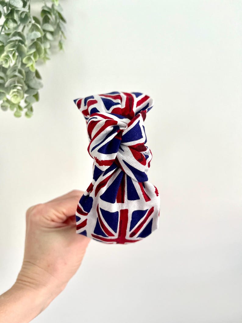 Puede incluir: Una diadema blanca anudada con un patr&oacute;n de Union Jack rojo, blanco y azul.