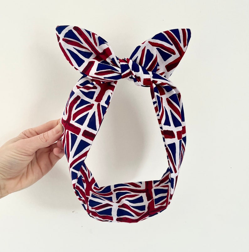 May include: A red, white, and blue headband with a Union Jack pattern. The headband is tied in a bow at the top.