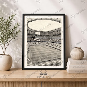 Peut inclure: Une impression encadrée en noir et blanc représentant l'intérieur du stade Allianz Arena à Munich, en Allemagne. L'image montre le terrain de football, les gradins et le logo du FC Bayern Munchen affiché sur le mur du stade.