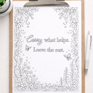 May include: A clipboard with a white paper featuring a floral border design and the text "Carry what helps. Leave the rest." A pen rests on the right side. The clipboard has a silver clip and a brown backing.