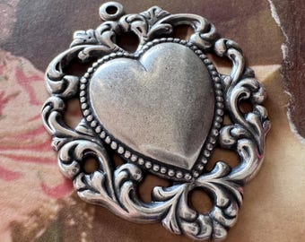 Dije de corazón de latón con borde de encaje, acabado en plata de ley
