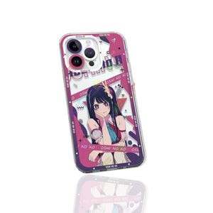 May include: Clear phone case with a colorful anime graphic. The case features a smiling anime girl with long black hair, wearing a red and blue outfit. The case has a pink and purple border with the text "OSHI NO KO".
