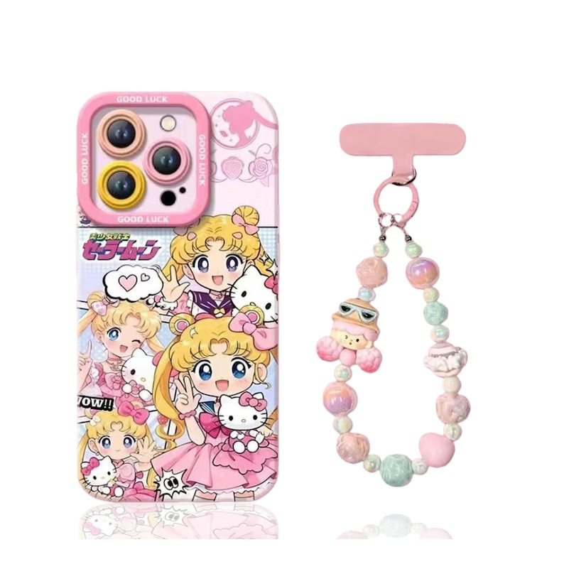 May include: Pink phone case with a cartoon design featuring a blonde anime character and Hello Kitty. The case has a camera cutout with the words "Good Luck" printed around it. A beaded phone charm with a cartoon character is also included.