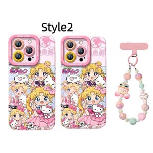 May include: Pink phone cases with a cartoon illustration of a blonde girl in a sailor suit and a Hello Kitty character. The cases have a pink camera lens protector with the words "GOOD LUCK". A matching beaded phone charm is also included.