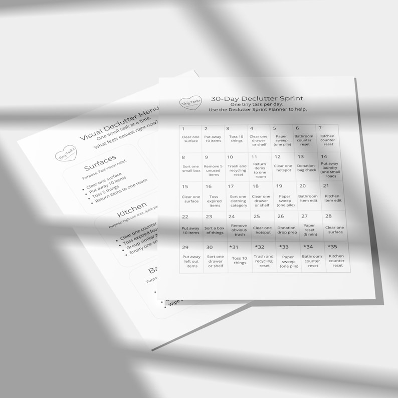 Puede incluir: Dos hojas de papel blanco con texto, que incluyen un planificador de Sprint de Despeje de 30 d&iacute;as y un Men&uacute; de Despeje Visual. El planificador tiene casillas numeradas para tareas diarias. El men&uacute; enumera tareas de despeje para superficies y la cocina.