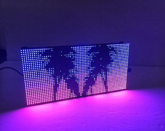 May include: A rectangular LED matrix display panel featuring a grid of illuminated dots. The screen shows a dark silhouette of two palm trees against a vibrant gradient background that transitions from deep blue at the top to bright pink at the base.
