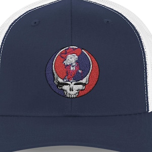 May include: Navy blue and white trucker hat featuring an embroidered Steal Your Face logo. The logo is a skull with a red, white, and blue design. The hat has a curved brim and a mesh back.