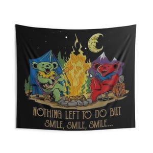 May include: A black tapestry featuring two cartoon bears camping by a campfire under a starry night sky. One bear plays a guitar, while the other sips from a mug. The text reads, "NOTHING LEFT TO DO BUT SMILE, SMILE, SMILE..."