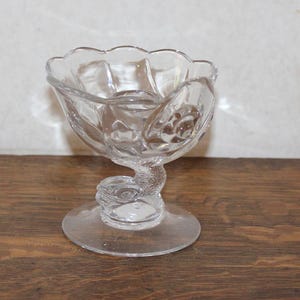 May include: A set of three ceramic mugs with a speckled, matte finish. The mugs are in shades of cream, light gray, and dark gray. Each mug has a simple, minimalist design and a rounded handle.