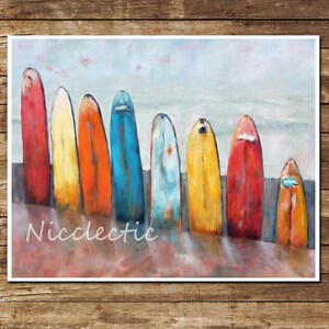 May include: A painting depicting eight colourful surfboards arranged on a sandy beach. The surfboards are painted in shades of red, orange, yellow, blue, and green. The background is a hazy blue sky.