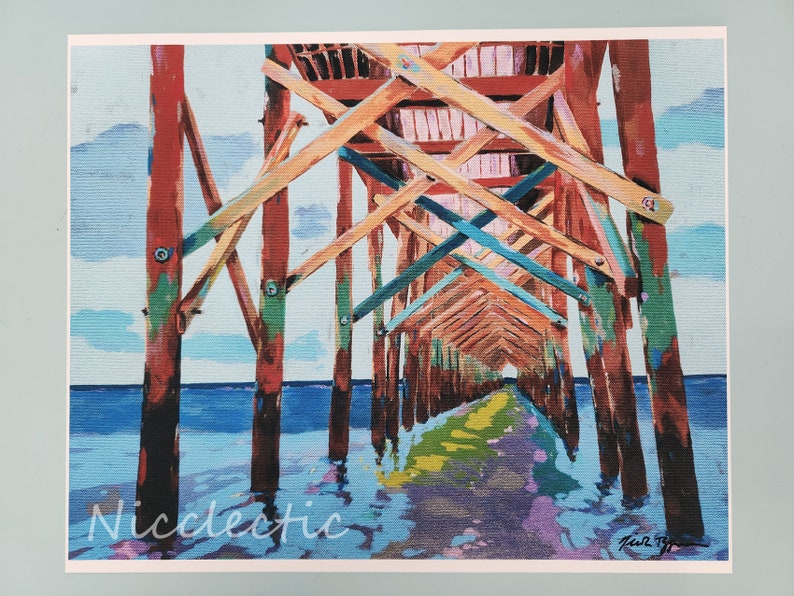 以下が含まれることがあります： 海に伸びる木製の桟橋を描いたカラフルな絵画。桟橋は赤、黄、青、緑の色合いで塗られています。水は濃い青色で、空は薄い青色で白い雲があります。絵画は右下に「Karl B. Young」と署名されています。