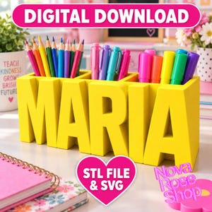 May include: A bright yellow desk organizer shaped like the name MARIA in block letters, featuring multiple compartments filled with various colored pencils and markers. The organizer is designed for holding stationery items on a flat surface.