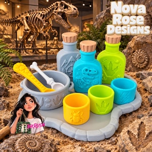 May include: A silicone feeding set featuring a gray bowl with a dinosaur footprint, a yellow spoon, a white bone-shaped spoon, three bottles in gray, blue, and lime green with embossed dinosaur and nature motifs, and three small cups in yellow, green, and blue.