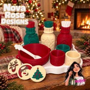 May include: A holiday-themed silicone dinnerware set featuring a red bowl with a white spoon, three bottles with lids in green, cream, and red, and three small cups. Three round plates display a reindeer, a snowman, and a Christmas tree.