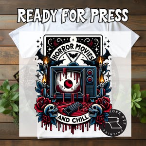 May include: White t-shirt with a graphic design featuring a vintage television with a bloody eyeball on the screen, surrounded by roses, skulls, and the words "HORROR MOVIES AND CHILL." The shirt also has the text "READY FOR PRESS."