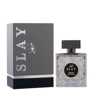 Może przedstawiać: Zestaw butelki i pudełka perfum. Pudełko jest ciemnoszare z napisem "SLAY" dużymi, srebrnymi literami. Butelka perfum jest kwadratowa z teksturowaną nakrętką.