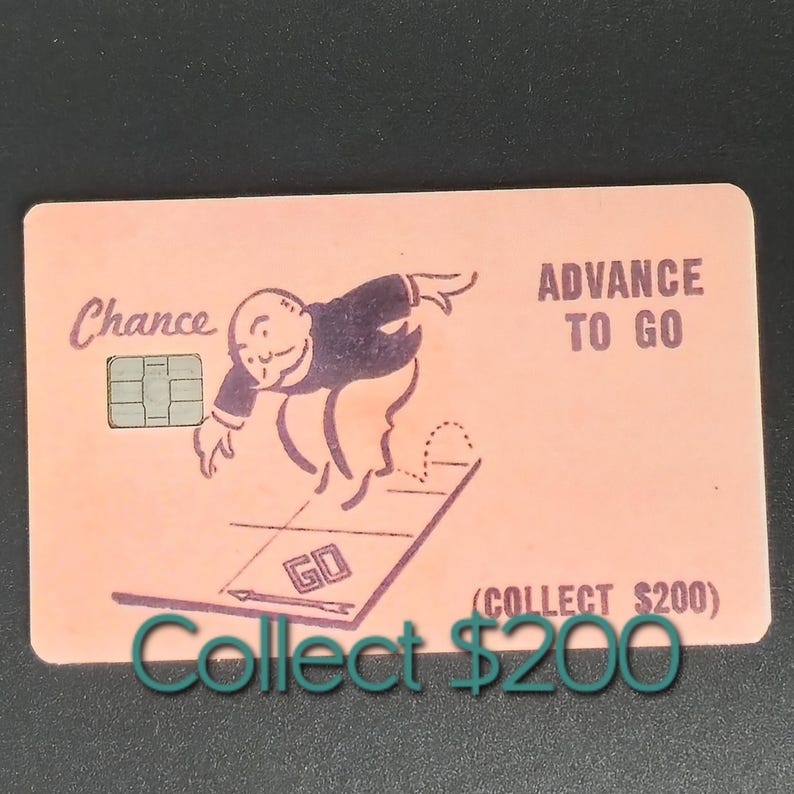 May include: A pink Monopoly Chance card with the text "Chance" and "Advance to Go." The card features a cartoon character and the text "Collect $200."