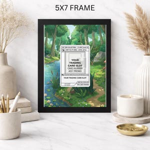 May include: A black 5x7 frame displays a colorful illustration of a forest scene with a river and a path. The frame holds a trading card slot with text that reads "YOUR TRADING CARD SLOT" and "#051 PROMO".