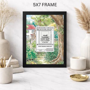 May include: A black 5x7 frame displaying a colorful illustration of a house and a path through a forest. The frame holds a trading card slot with the text "YOUR TRADING CARD SLOT" and card number #106/094.