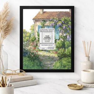 May include: Black 8x10 frame with a watercolor print of a European cottage with blue shutters, surrounded by lush greenery and flowers. The print includes text that reads "YOUR TRADING CARD SLOT".