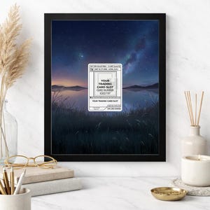 May include: Black 8x10 frame with a landscape print of a lake and starry night sky. A white card with the text "YOUR TRADING CARD SLOT" and "CARD NUMBER #202/197" is in the center. The frame is on a white surface.