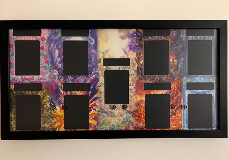 Puede incluir: Marco de exhibici&oacute;n negro con m&uacute;ltiples aberturas rectangulares. El fondo presenta coloridas obras de arte florales y fant&aacute;sticas. El marco es rectangular y est&aacute; montado en una pared blanca.