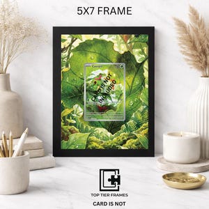 Puede incluir: Un marco negro de 5x7 que contiene una impresi&oacute;n de un personaje Caterpie verde sobre una hoja grande. El marco presenta el texto 5X7 FRAME en la parte superior y TOP TIER FRAMES CARD IS NOT INCLUDED en la parte inferior. La tarjeta tiene el texto CARD IS NOT INCLUDED.
