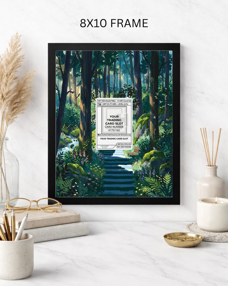 May include: A framed 8x10 print featuring a forest scene with a path leading through trees. The artwork includes a white label with the text "YOUR TRADING CARD SLOT" and a card number. The frame is black.