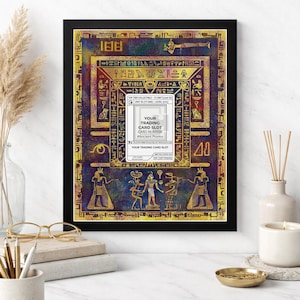 May include: An 8x10 framed print with an ancient Egyptian theme. The artwork features hieroglyphs, pharaoh figures, and a central area for a trading card slot. The frame is black, and the print has gold, blue, and red tones.