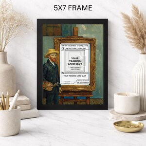 May include: A black 5x7 frame displaying a print of a painting of Vincent van Gogh. The painting includes a gold frame with a white trading card slot. The text "YOUR TRADING CARD SLOT" is visible. The frame is displayed on a white surface.