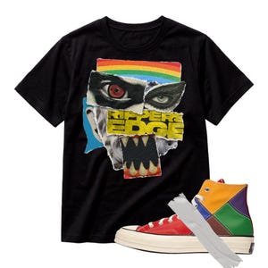 May include: A black short-sleeved t-shirt featuring a collage graphic with a rainbow, eyes, and the text RIPPERS EDGE above a monster mouth with sharp teeth. Beside it is a high-top trainer with red, yellow, green, and purple panels and white tape.