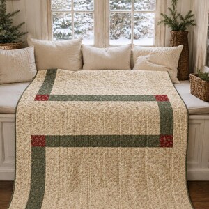 May include: A rectangular quilt featuring a cream-colored fabric with a small-scale floral pattern. The design includes a border of dark green fabric strips accented by small, square patches of red floral fabric at the corners of the pattern.