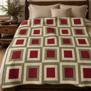 Può includere: Una trapunta con un motivo a blocchi ripetuti di quadrati rosso scuro centrati all'interno di bordi verde salvia e cornici color crema. Il tessuto presenta una sottile trama punteggiata su tutto il design, creando una griglia geometrica.