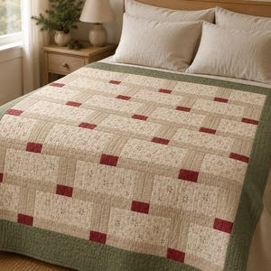Puede incluir: Una colcha acolchada con un diseño de patchwork de bloques rectangulares en color crema con un pequeño estampado floral, separados por tiras beige lisas y acentuados con pequeños parches de tela cuadrados en rojo oscuro, con un borde ancho verde oliva.