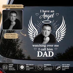 Puede incluir: Una calcomanía de vinilo blanco para coche con una foto personalizada de un hombre centrada entre dos grandes alas de ángel y un halo. El texto dice: I have an Angel watching over me I call him DAD, decorado con cuatro pequeños corazones.