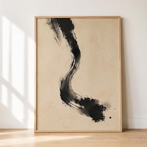 Può includere: Stampa artistica astratta con un'audace pennellata nera su sfondo beige, incorniciata in una cornice di legno naturale. La pennellata fluida crea una sensazione di movimento ed energia. L'estetica minimalista è moderna e adatta a vari interni.