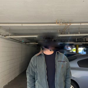 Pu&ograve; includere: Giacca da lavoro color verde acqua con colletto marrone e chiusura a zip. La giacca presenta un piccolo logo quadrato sul petto e una tasca con zip sulla parte superiore sinistra. Sotto &egrave; indossata una maglietta nera.